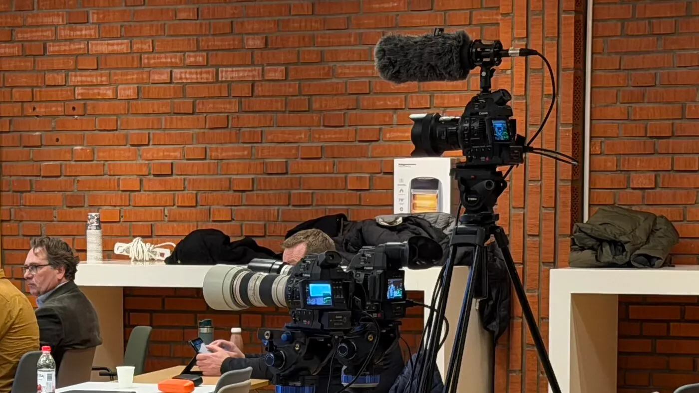 Canon Cine-kameror riggade under pågående sändning — teleobjektiv och sökare, salen i bakgrunden.